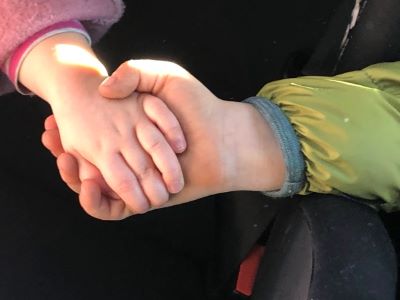 Zwei Kinderhände im Händedruck – Symbol für Zusammenhalt und Vereinbarkeit von Familie und Business