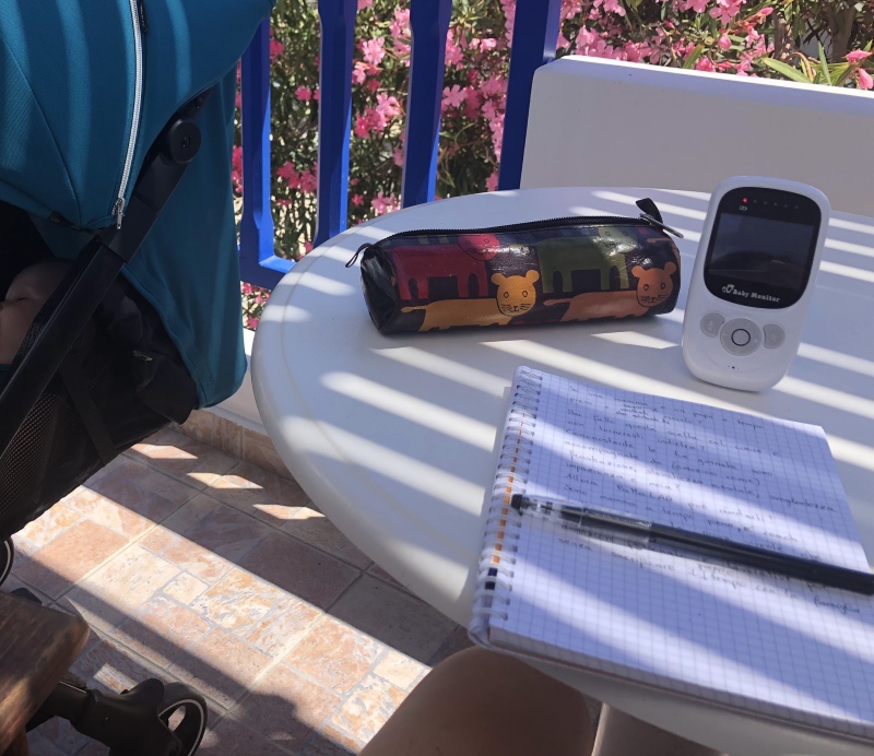 Terrassentisch mit Notizbuch und Kinderwagen – Symbol für Vereinbarkeit von Familie und Business im Freelance-Alltag